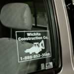 Weatherproof label of white bulldozer on transparent polyester square for Wichita Construction on car window.