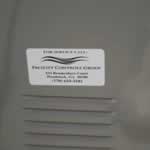 Black text and wavy lines on white vinyl rectangle Facility Control Group weatherproof label on heating unit