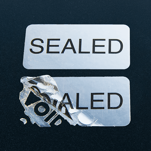 Silver rectangular warning label with VOID residue pattern