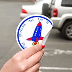 Blue and red rocket graphic on white circle Proud To Be custom static cling decal on window