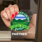 Green farm and red barn circle graphic on clear square Local Food Fresher custom window decal on glass.