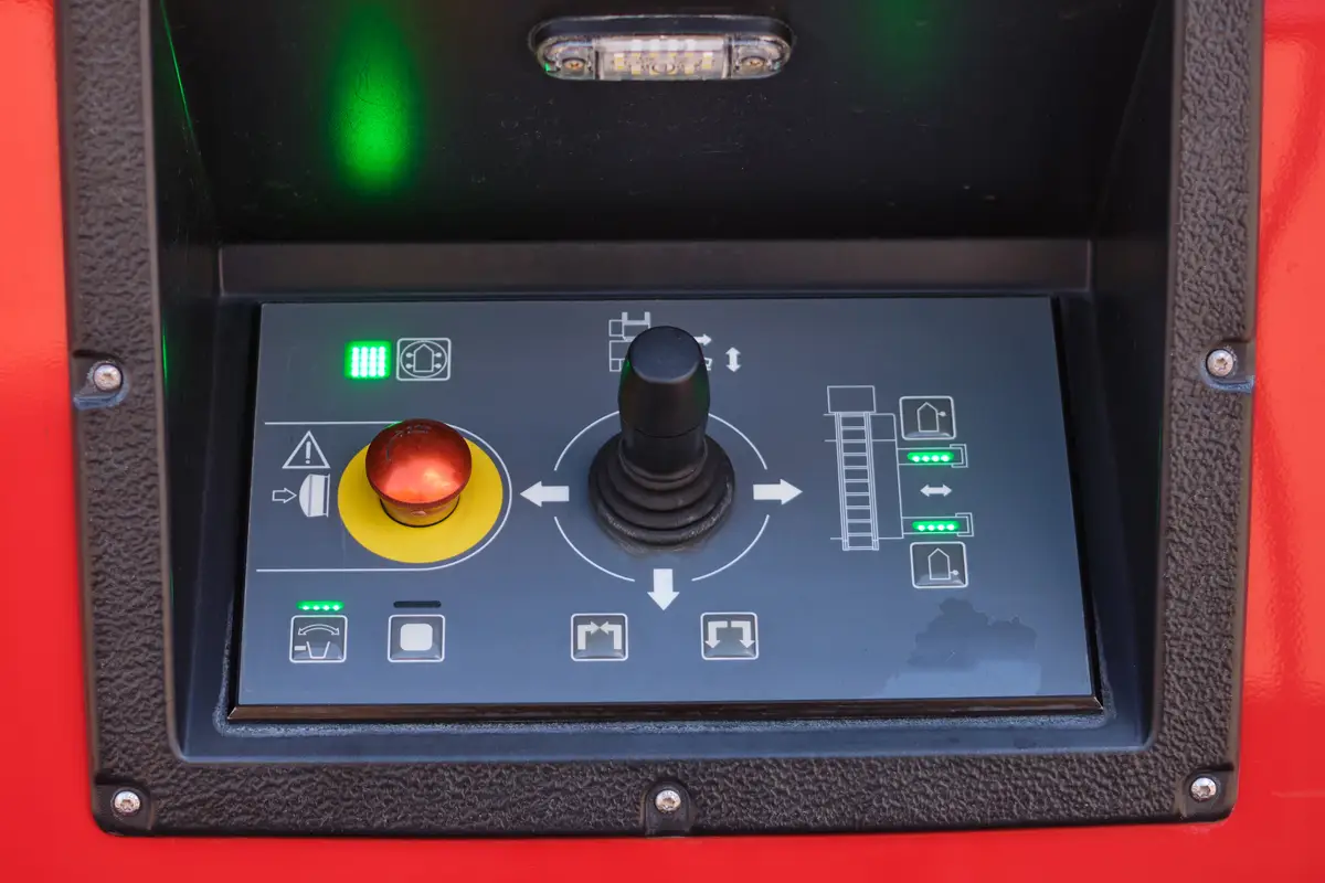 Control panel labels with joystick, emergency stop button, and indicator lights.