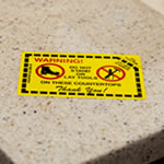 Custom rectangle yellow warning label with red and black print and adhesive on back.