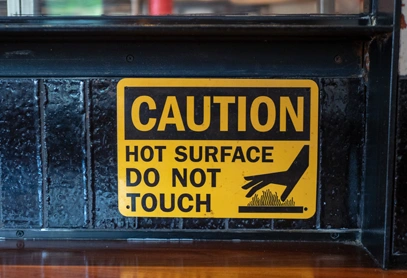 Healthcare Warning Label for Hot Surface Safety A yellow healthcare warning label stating "Hot Surface Do Not Touch," designed to prevent burns and ensure safety in medical or clinical environments.